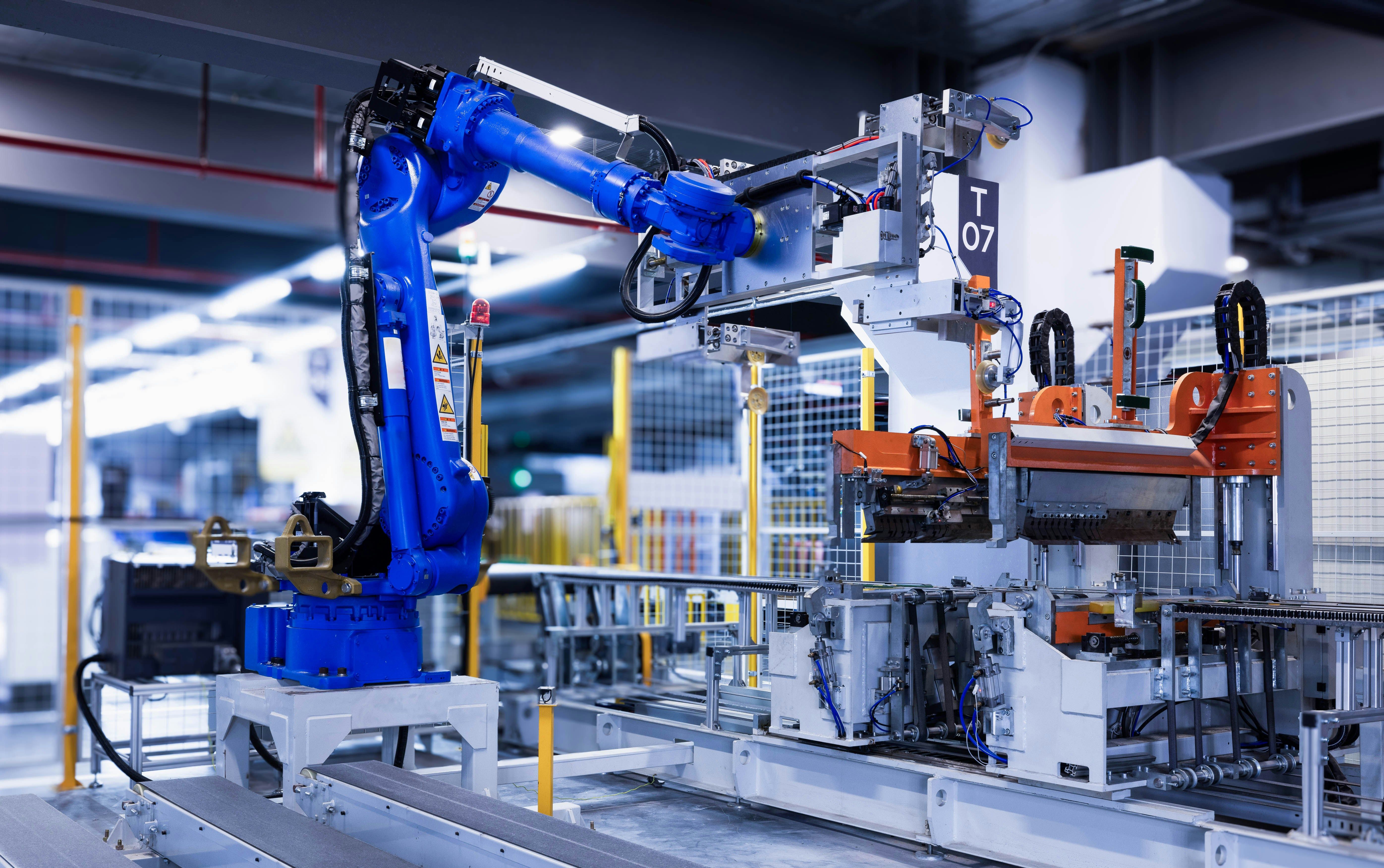 Blue industrial robot arm working in a factory