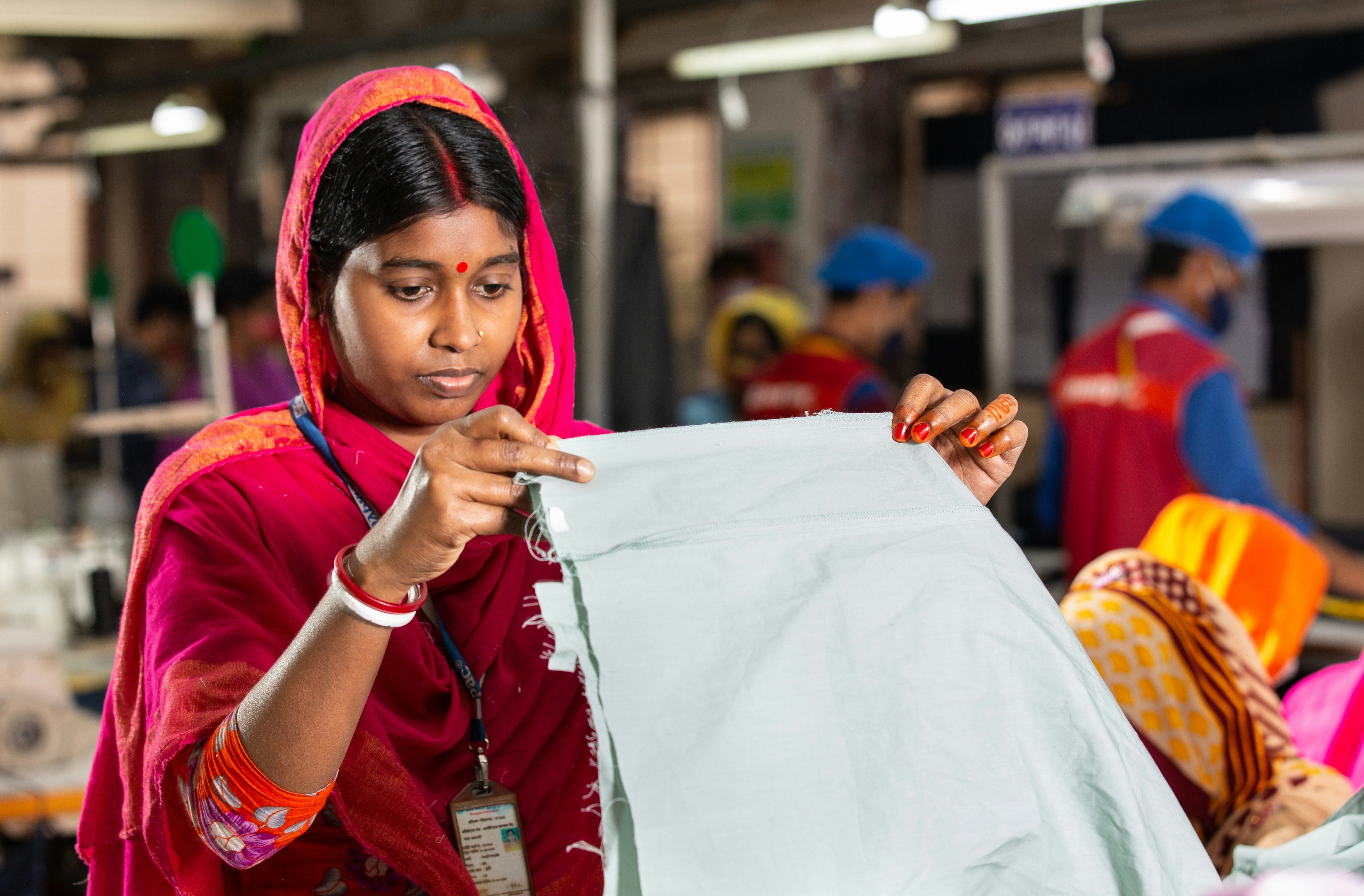 Woman inspecting fabric in a factory setting