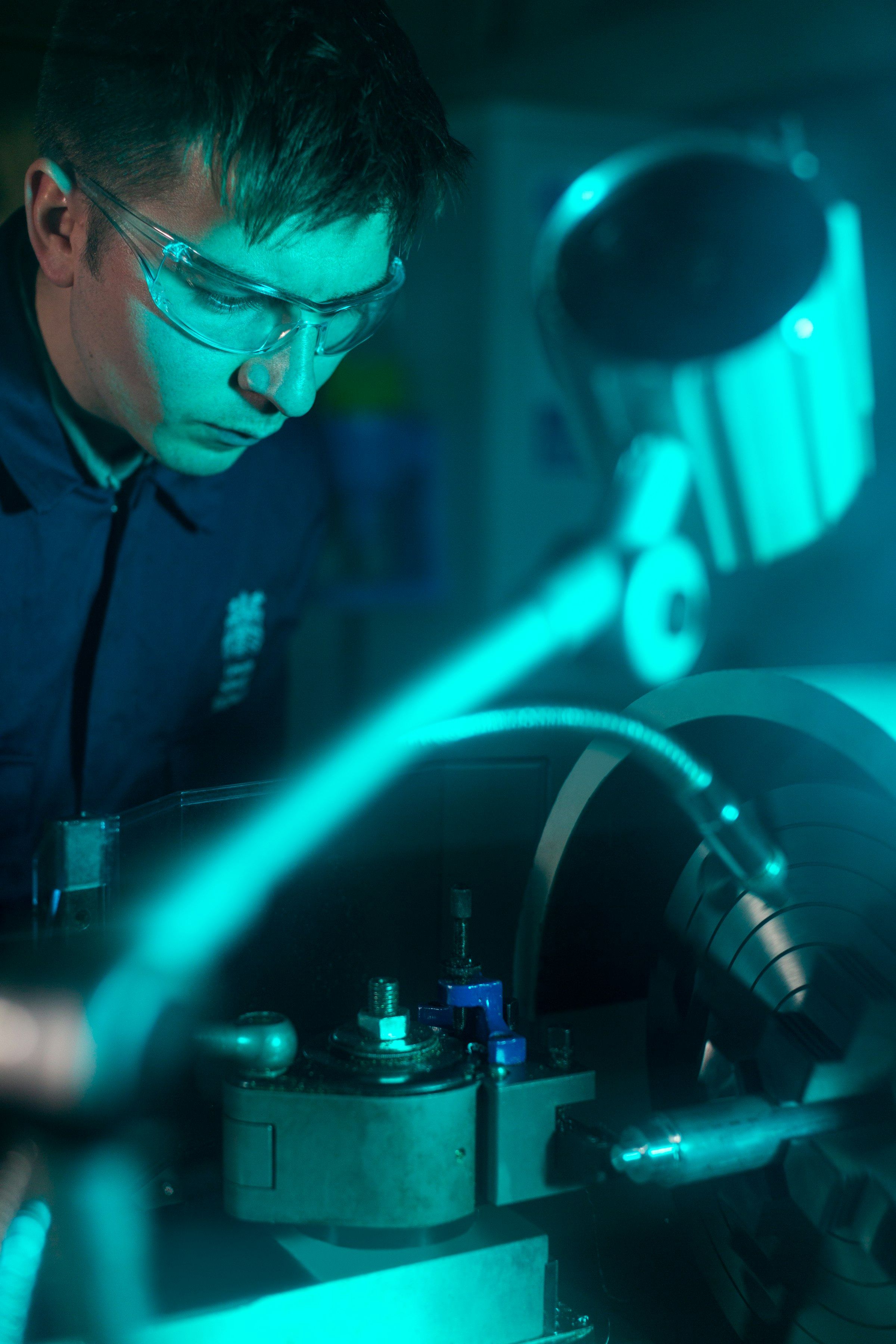 Technician using a diagnostic sensor to read data from a running machine