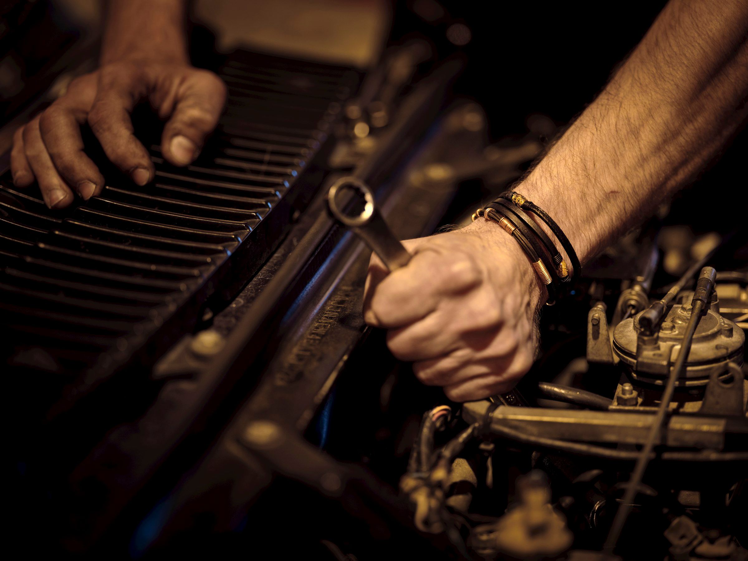 Technician's hands using a wrench during scheduled equipment servicing